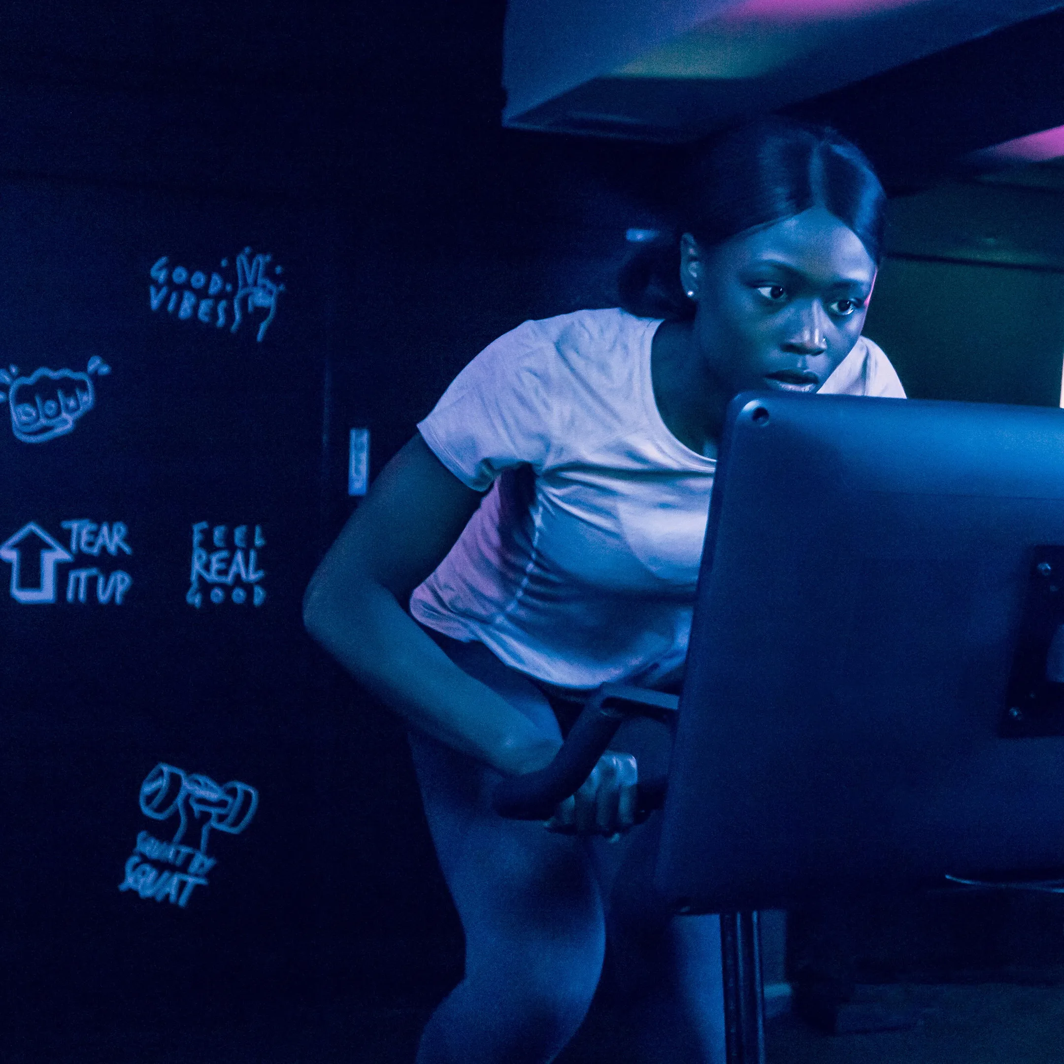 Vrouw traint op de Body Bike SMART+ SWITCH in het licht van het touchscreen tijdens de shoot in Londen. Fotografie door Fitbrand.