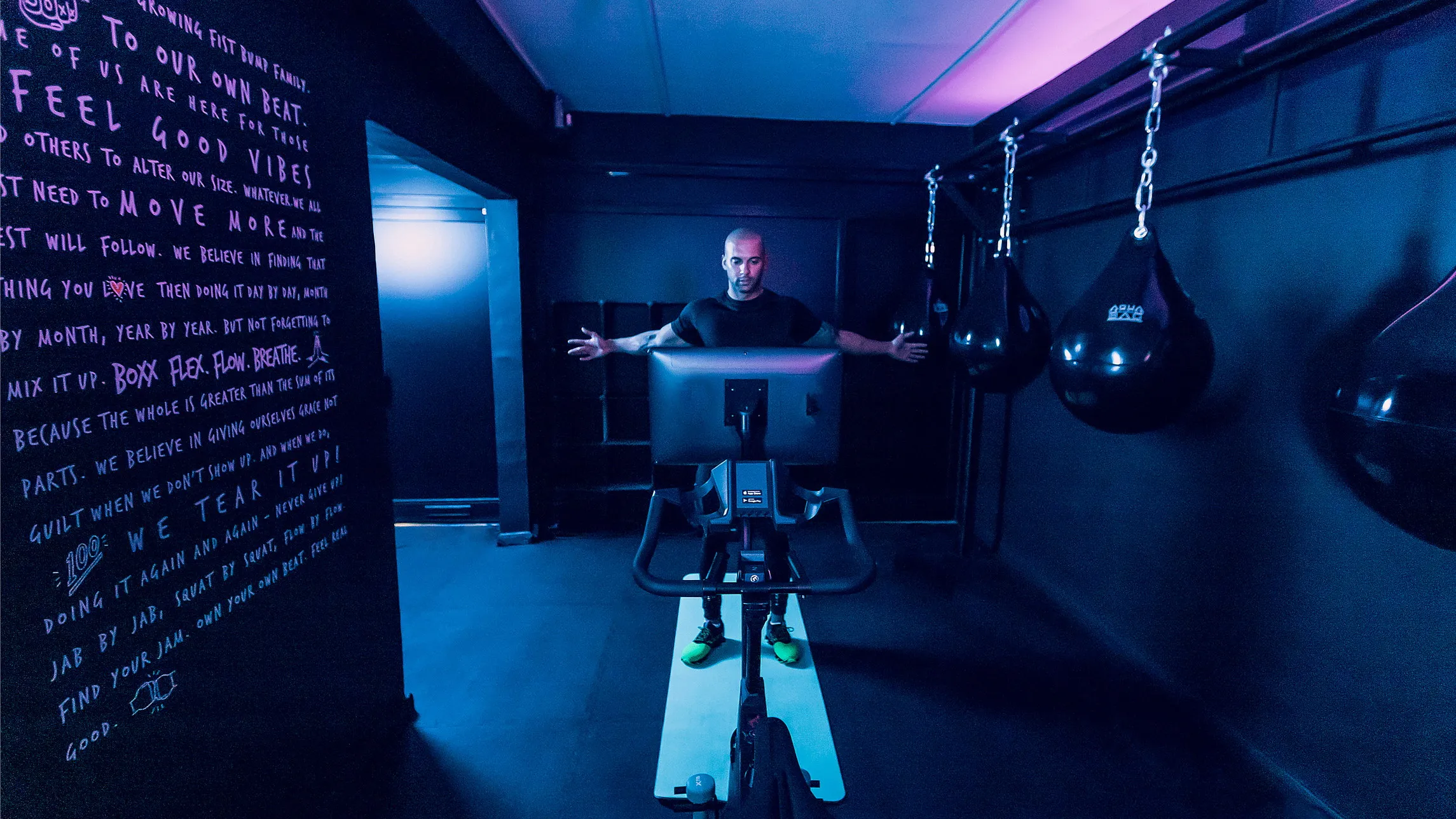 Body Bike SMART+ SWITCH in een boutique cycling studio in Londen, met bokszakken en handgeschreven muurtekst. Fotografie door Fitbrand.