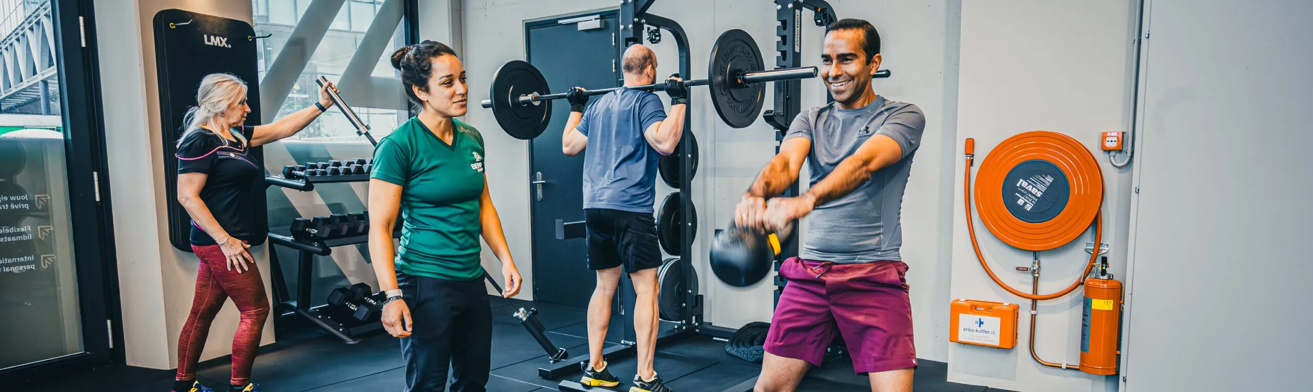 Groep traint met kettlebell en halter bij BeneFIT Studio Den Haag City. Fotografie door Fitbrand