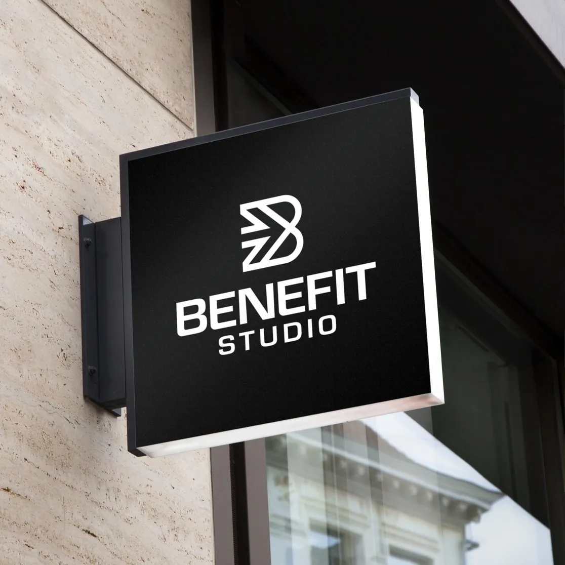 Zwarte lichtbak met het logo van BeneFIT Studio aan een gevel van natuursteen. Door Fitbrand